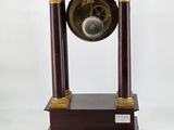 a clock that is sitting on a stand with a key