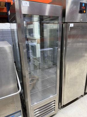 several stainless steel refrigerators are lined up in a warehouse