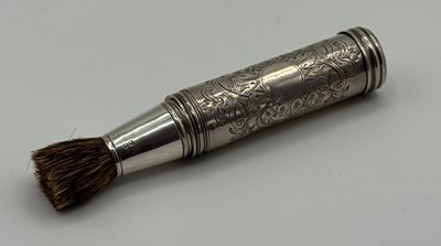 une petite brosse en argent posée sur une table