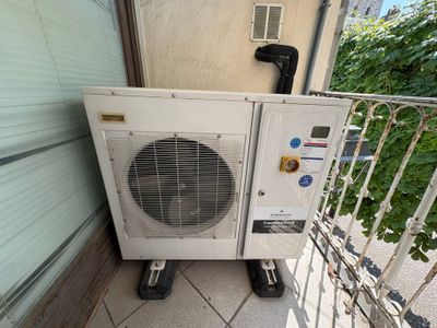 a small air conditioner sitting on the side of a building