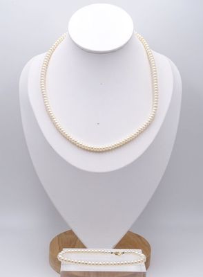 un mannequin blanc portant un collier et un bracelet, posé sur un socle en bois