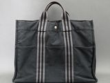 a black and white striped tote bag on a gray background
