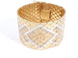 un gros plan d'un bracelet en or et en argent sur fond blanc
