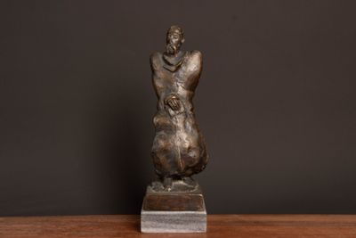 statue of a woman holding a child on a wooden table