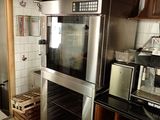 une cuisine équipée d'une cuisinière, d'un four, d'un micro-ondes et de placards