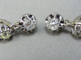 paire de boucles d'oreilles en argent ornées de pierres vertes sur un fond blanc