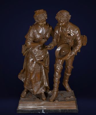 statue en bronze représentant un homme et une femme tenant un panier