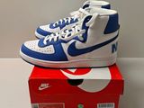 des baskets Nike Dunk montantes bleues et blanches posées sur une boîte rouge