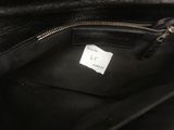 a close up of a black purse with a label on it