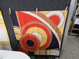 une table et une chaise dans une pièce où est accrochée une tapisserie au mur