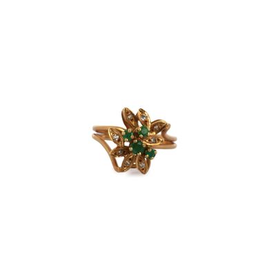 a close up of a gold ring with green and white stones