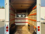 a white truck with a red stripe in the back
