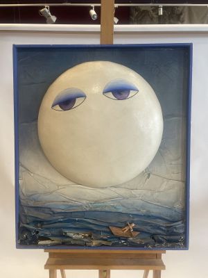 a painting on a easel with a painting of a moon in the background