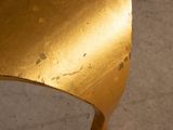 a close up view of a gold chair with holes in it