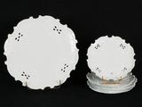 two white plates with lacy designs on them on a black background