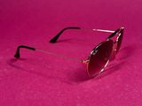 a pair of sunglasses on a pink surface with a pink background