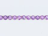 un gros plan d'une perle violette sur fond blanc