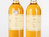 deux bouteilles de vin posées l'une à côté de l'autre sur une surface blanche