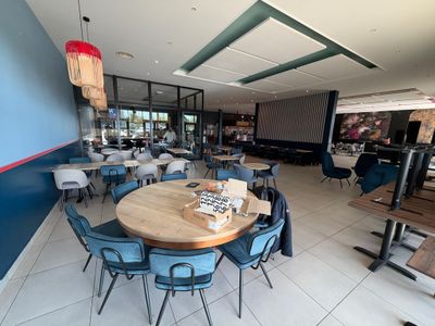 des tables et des chaises dans un restaurant aux murs bleus et au sol carrelé de blanc