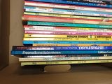 many books stacked on top of each other in a box