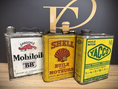 three cans of oil are sitting on a table next to each other