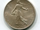 l'image d'une pièce de monnaie sur laquelle figure une femme, posée sur une surface blanche