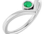 une bague en or blanc sertie d'une émeraude au centre