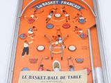 an orange box with a pinball game in it on a white surface