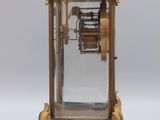 a clock that is sitting on a stand on a white surface