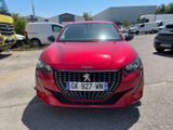 the front of a red car parked in a parking lot with other cars in the background