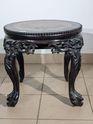 a black table with a marble top on a tiled floor