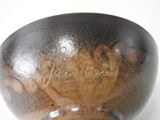 a brown vase with writing on it sitting on a table