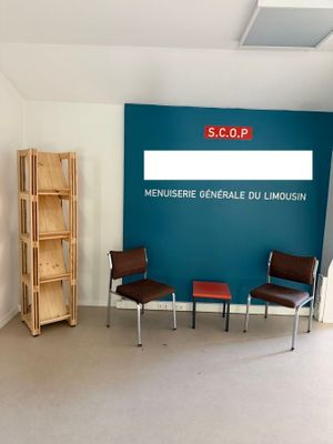 une photo d'une salle d'attente avec des chaises et un panneau