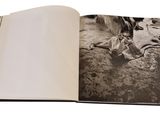 an open book with a black and white photo of a dog laying on the ground