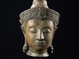 une tête de Bouddha en bronze sur fond noir