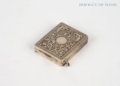 a small silver book on a white surface