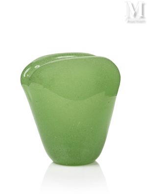 un vase en verre vert posé sur une table blanche