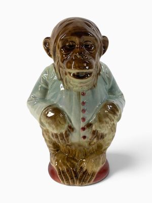 une figurine en céramique représentant un singe portant une chemise bleue