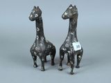 paire de figurines en bronze représentant des girafes sur fond gris