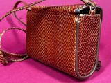 an image of a brown purse on a pink background