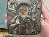 someone is holding a small metal box with a picture of jesus on it