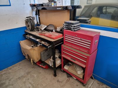 a garage with a workbench, tool chest, and other tools