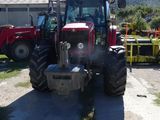 a red tractor that is parked in the dirt