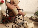 un ours en peluche assis dans une poussette à côté d'un petit chien