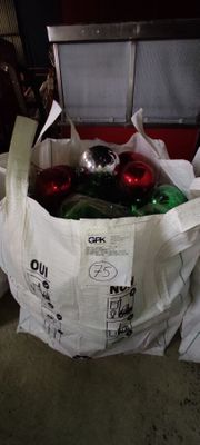 a bag full of christmas ornaments sitting on the floor