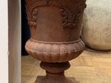 a vase that is sitting on the floor next to a wall
