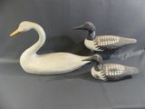 trois canards sculptés posés les uns à côté des autres sur une table