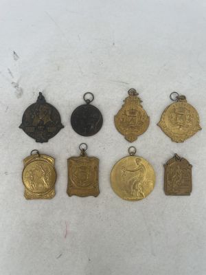 a group of five medals and a medal on a white surface