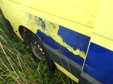 a yellow and blue van that is parked in the grass