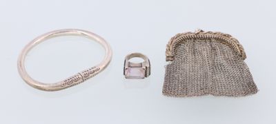 deux bagues en argent et une pochette en argent posées sur une surface blanche